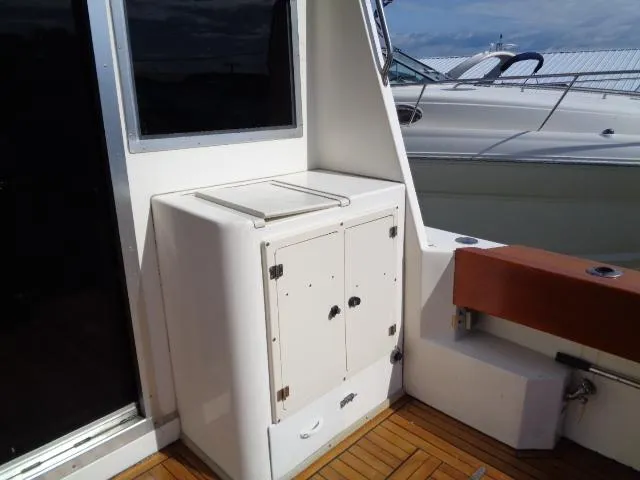 Slide: The Image of 1999 Albemarle 325 Convertible boat interior with storage cabinet and wooden deck. - 24