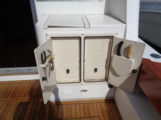 Slide: The Image of 1999 Albemarle 325 Convertible boat storage with open cabinets and tools on deck. - 25