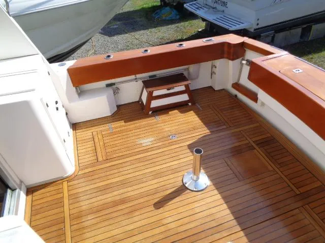 Slide: The Image of 1999 Albemarle 325 Convertible boat deck with wooden flooring and seating area. - 27