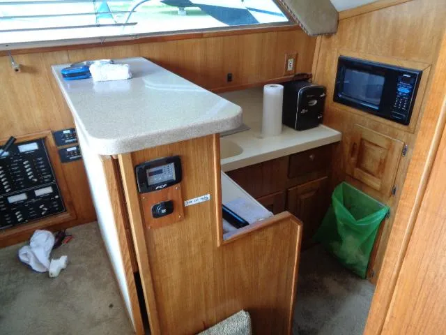 Slide: The Image of 1999 Albemarle 325 Convertible boat interior with kitchenette, microwave, and control panel. - 39