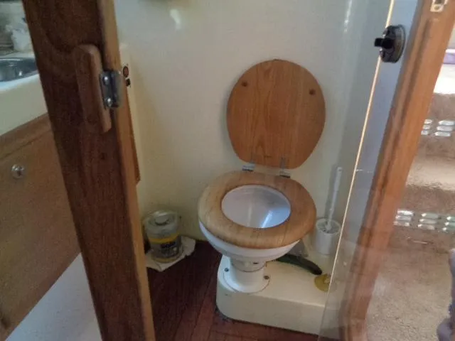 Slide: The Image of 1999 Albemarle 325 Convertible boat bathroom with wooden toilet seat and compact design. - 44