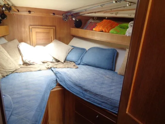 Slide: The Image of Cozy cabin interior of 1999 Albemarle 325 Convertible with blue bedding and wooden accents. - 48