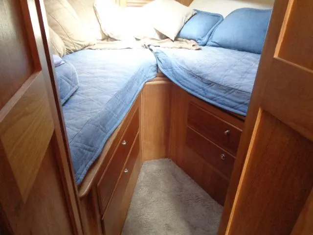Slide: The Image of 1999 Albemarle 325 Convertible cabin with blue bedding and wooden storage drawers. - 49