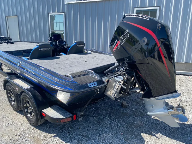 Slide: The Image of 2025 Phoenix 721 ZXL boat with powerful outboard motor, parked on gravel near a building. - 8