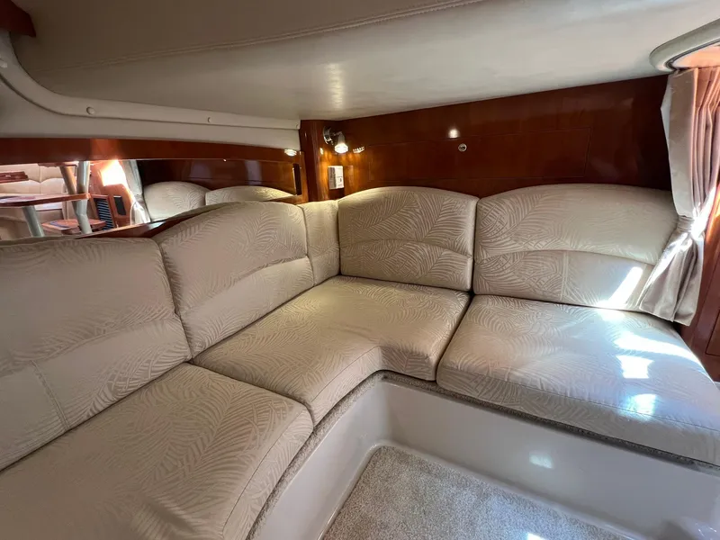 Slide: The Image of 2006 Four Winns 348 Vista interior with beige cushioned seating and wood paneling. - 12
