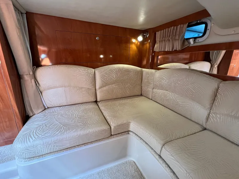 Slide: The Image of 2006 Four Winns 348 Vista cabin interior with beige seating and wood paneling. - 13