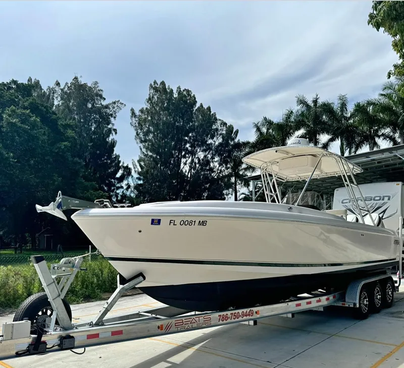Slide: The Image of 2001 Intrepid 327 Center Console boat on trailer, surrounded by trees. - 1