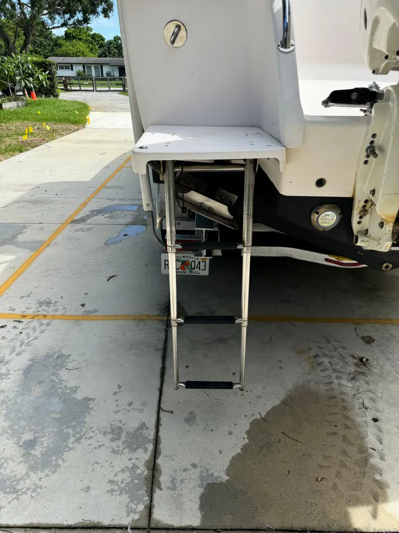 Slide: The Image of 2001 Intrepid 327 Center Console boat with extended swim ladder on a concrete driveway. - 12