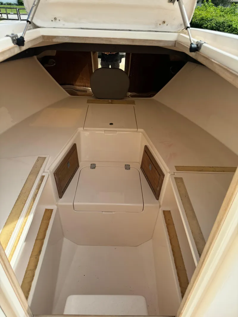 Slide: The Image of 2001 Intrepid 327 Center Console cabin interior with storage compartments and seating. - 23