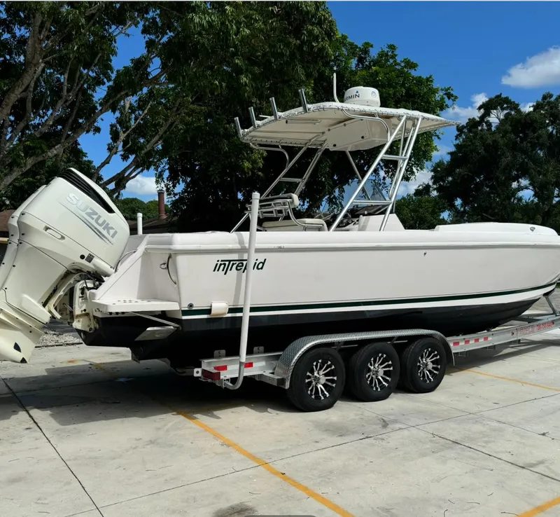 Slide: The Image of 2001 Intrepid 327 Center Console boat on trailer, parked outdoors. - 3