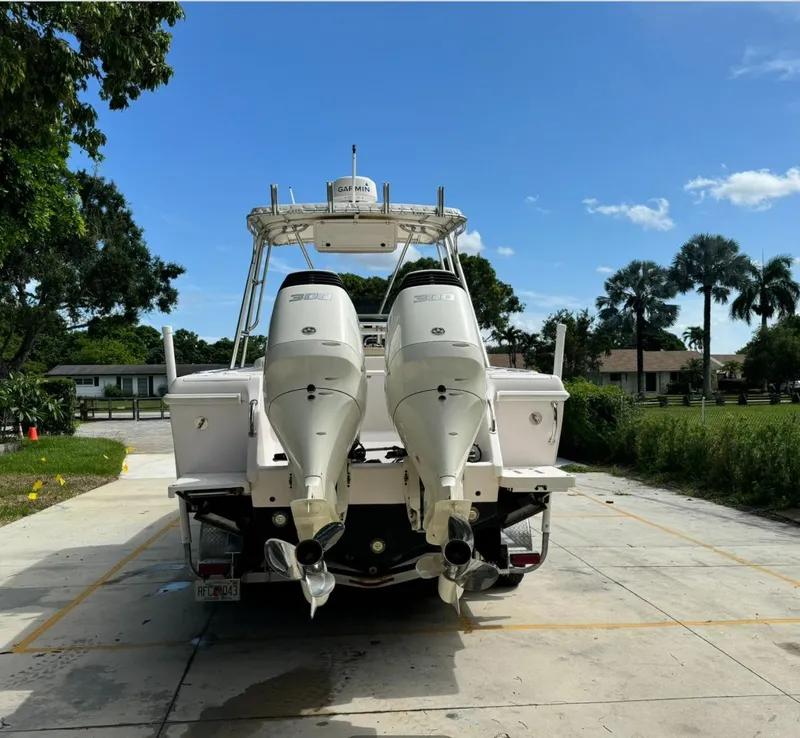 Slide: The Image of 2001 Intrepid 327 Center Console boat with dual outboard motors, parked outdoors. - 4