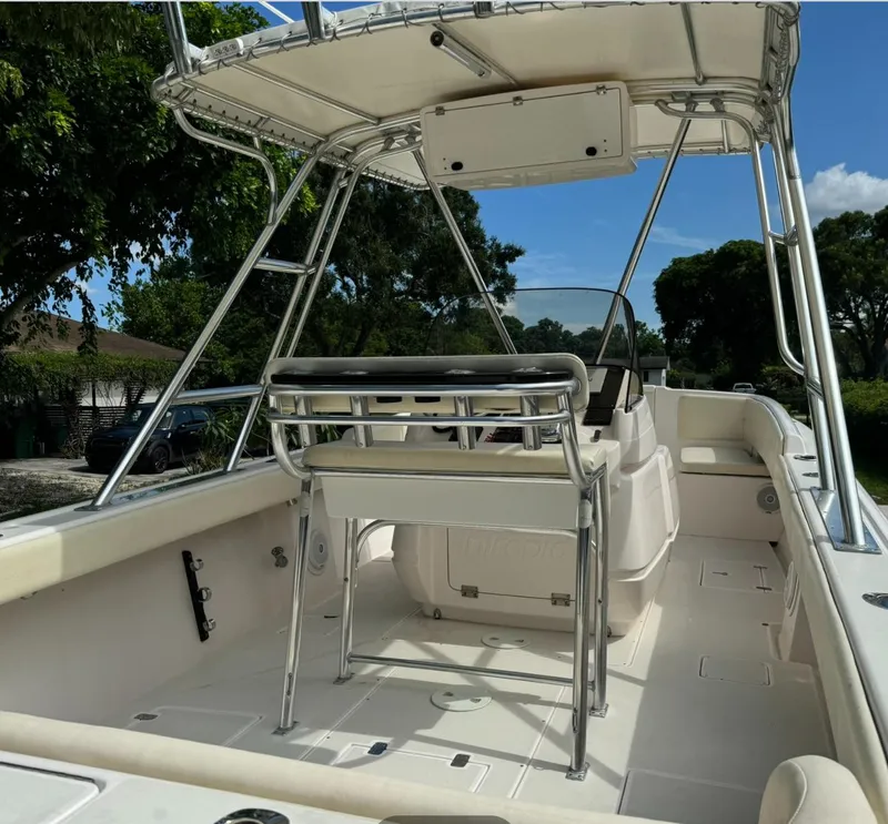 Slide: The Image of 2001 Intrepid 327 Center Console boat interior with seating and helm, under clear blue sky. - 5