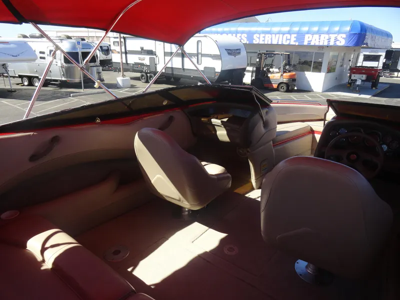 Slide: The Image of Interior of 2001 Crownline 202 BR LPX boat with red canopy and beige seating. - 14