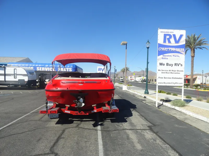 Slide: The Image of Red 2001 Crownline 202 BR LPX boat parked at RV service center under clear blue sky. - 20