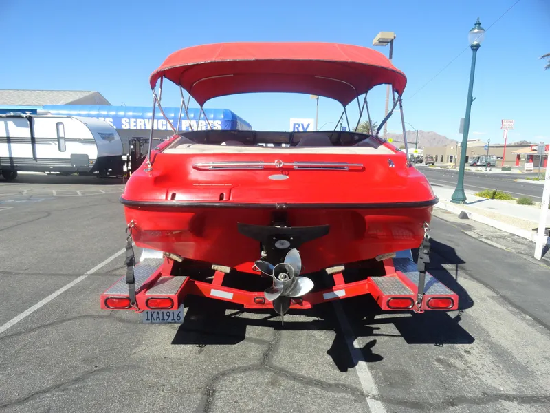Slide: The Image of Red 2001 Crownline 202 BR LPX boat with canopy, parked in a lot. - 21