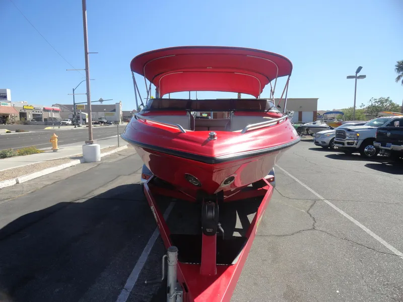 Slide: The Image of Red 2001 Crownline 202 BR LPX boat on trailer, parked in urban area under clear sky. - 3