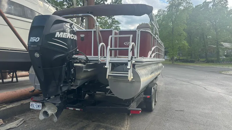 Slide: The Image of 2014 Harris Cruiser 240 pontoon boat with Mercury 150 engine, parked outdoors. - 3