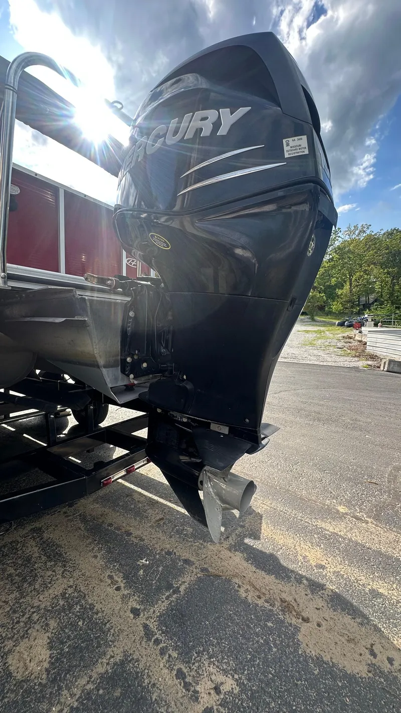 Slide: The Image of 2014 Harris Cruiser 240 with Mercury outboard motor, parked outdoors on a sunny day. - 4