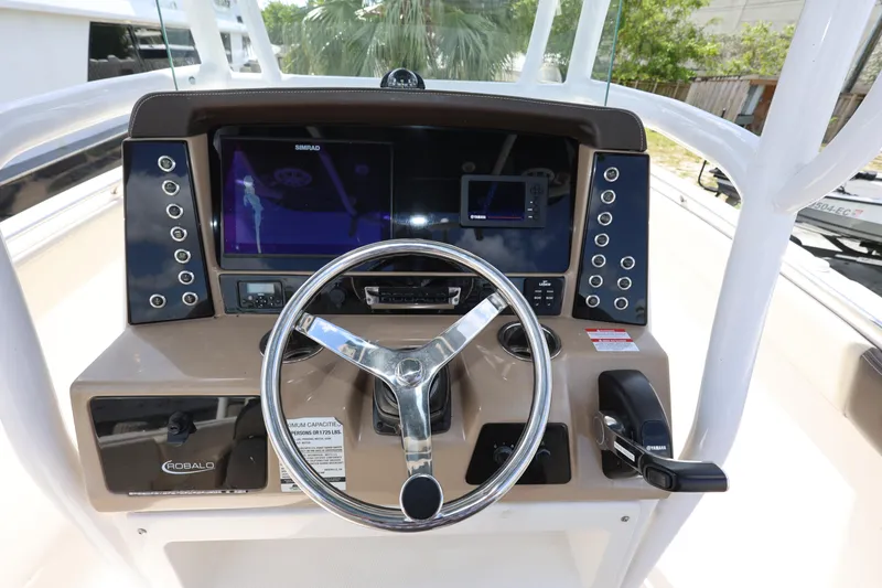Slide: The Image of 2019 Robalo R242 Explorer boat dashboard with steering wheel and navigation controls. - 12