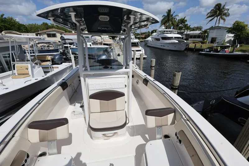 Slide: The Image of 2019 Robalo R242 Explorer boat docked in a marina, featuring spacious seating and sleek design. - 18