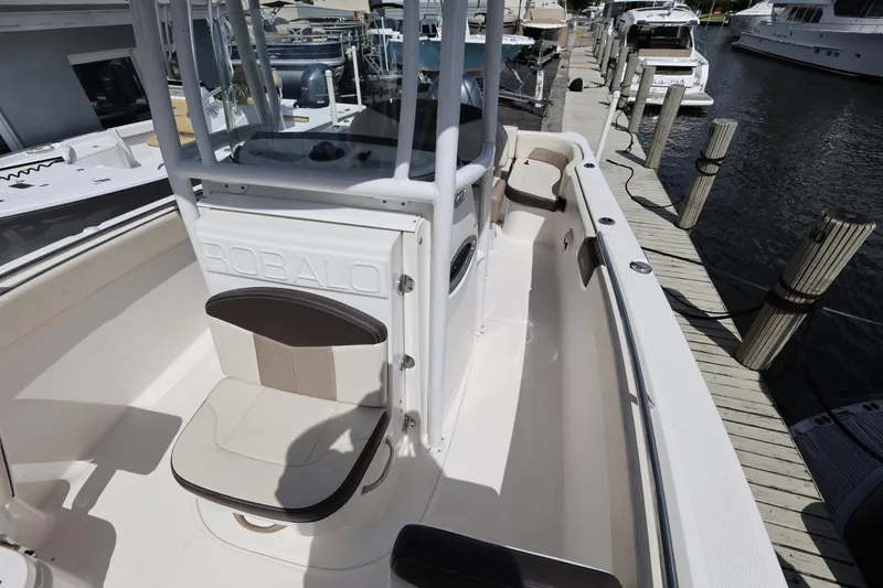 Slide: The Image of 2019 Robalo R242 Explorer boat docked, showcasing seating and helm area. - 19