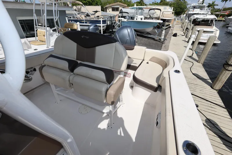 Slide: The Image of 2019 Robalo R242 Explorer boat interior with seating, docked at marina. - 22