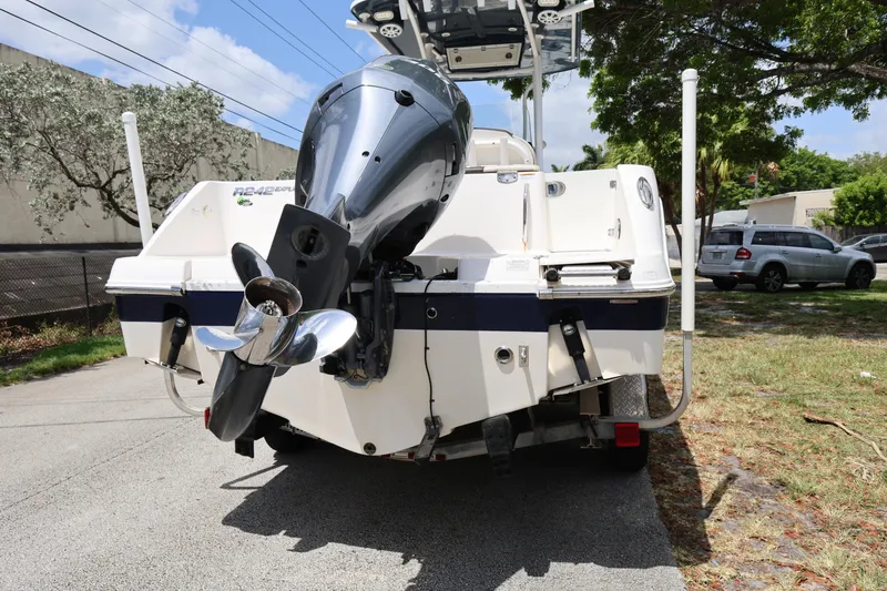 Slide: The Image of 2019 Robalo R242 Explorer boat with outboard motor, parked on a sunny street. - 4