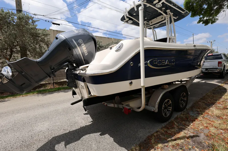 Slide: The Image of 2019 Robalo R242 Explorer boat on trailer, parked on a sunny street. - 5