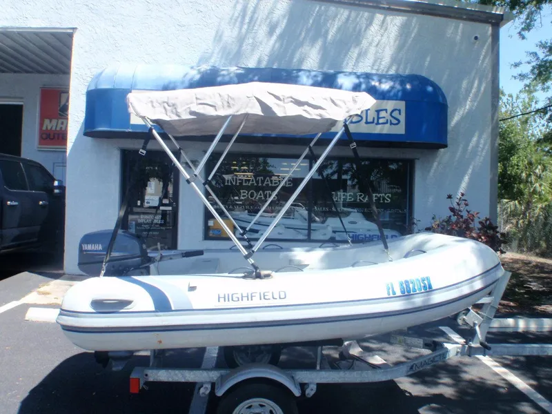 Slide: The Image of 2021 Highfield Classic 290 inflatable boat with canopy on trailer outside store. - 1