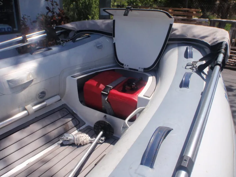 Slide: The Image of 2021 Highfield Classic 290 boat interior with open storage compartment and red fuel tank. - 2