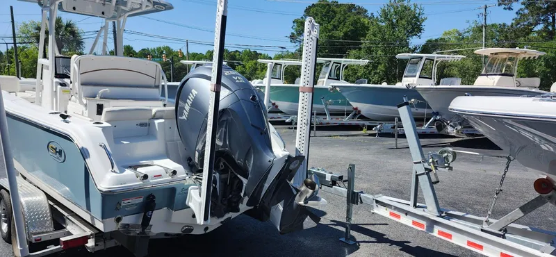 Slide: The Image of 2022 Sea Hunt Ultra 234 boat on trailer in a parking lot. - 2