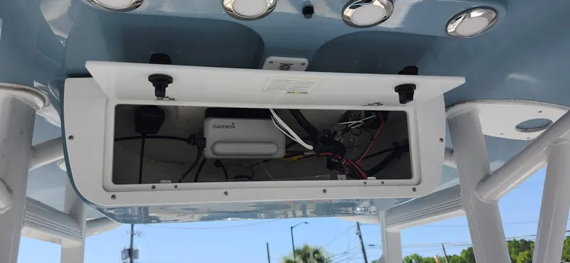 Slide: The Image of 2022 Sea Hunt Ultra 234 boat electronics compartment with wiring and equipment. - 5
