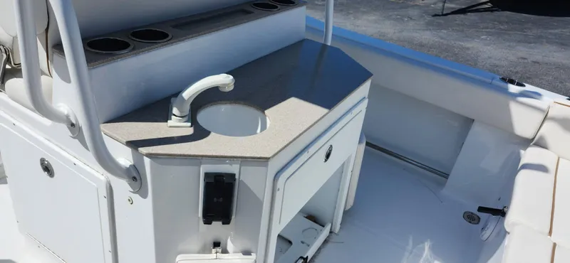 Slide: The Image of 2022 Sea Hunt Ultra 234 boat interior with sink and storage area. - 7