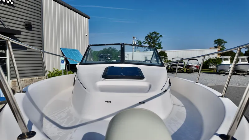 Slide: The Image of 1998 Bayliner Trophy 1802 Cuddy boat with windshield, docked near industrial buildings. - 14