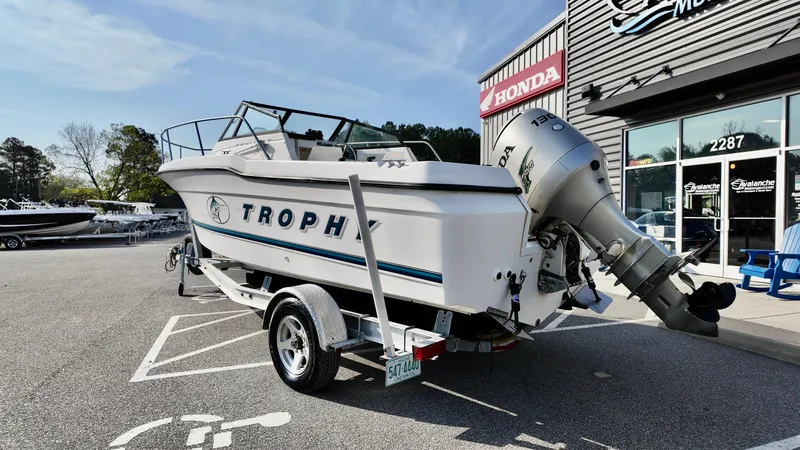 Slide: The Image of 1998 Bayliner Trophy 1802 Cuddy boat on trailer, parked outside dealership. - 2