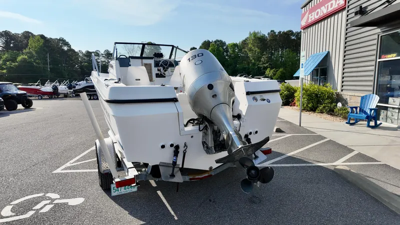 Slide: The Image of 1998 Bayliner Trophy 1802 Cuddy boat with outboard motor in a parking lot. - 3
