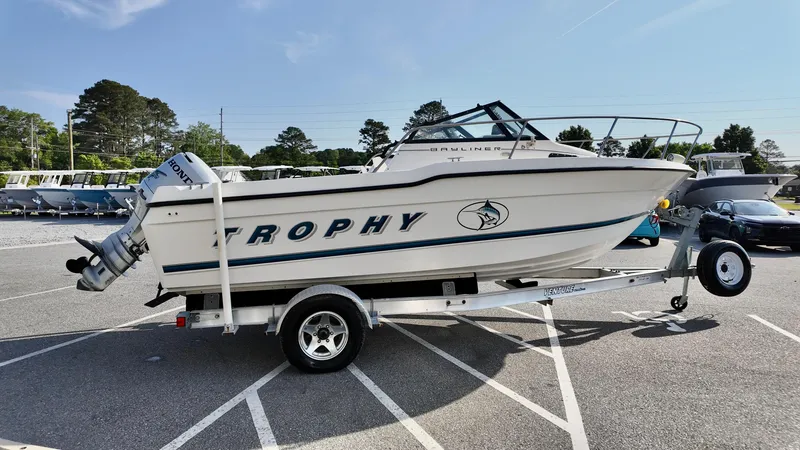 Slide: The Image of 1998 Bayliner Trophy 1802 Cuddy boat on trailer in parking lot. - 4