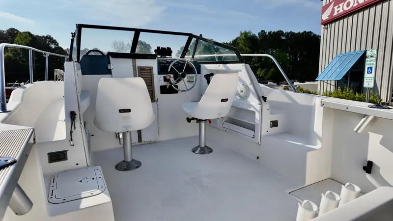Slide: The Image of 1998 Bayliner Trophy 1802 Cuddy boat interior with white seating and steering wheel. - 9