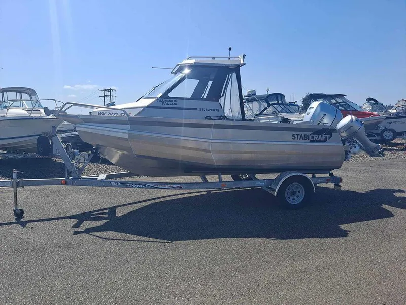 Slide: The Image of 2021 Stabicraft 1850 Supercab X1 boat on trailer, parked in a marina under clear blue sky. - 4
