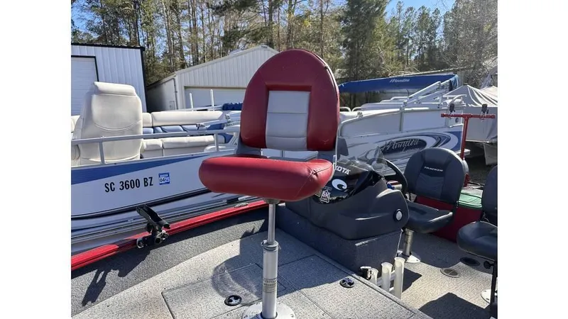 Slide: The Image of 2021 Tracker Super Guide V-16 SC boat with red seat, parked outdoors. - 2