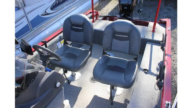 Slide: The Image of 2021 Tracker Super Guide V-16 SC boat interior with two gray seats and steering console. - 7