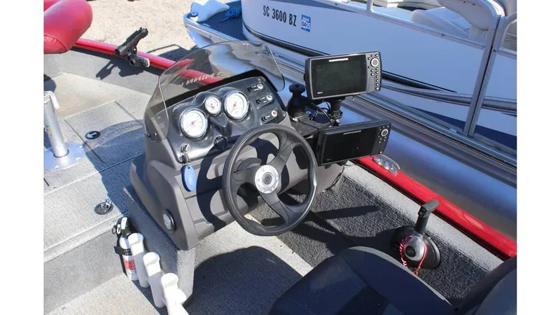 Slide: The Image of 2021 Tracker Super Guide V-16 SC boat dashboard with steering wheel and navigation equipment. - 9