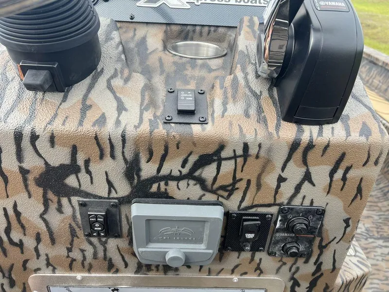 Slide: The Image of Control panel of 2025 Xpress X23B Lounge boat with camouflage design and Yamaha components. - 16