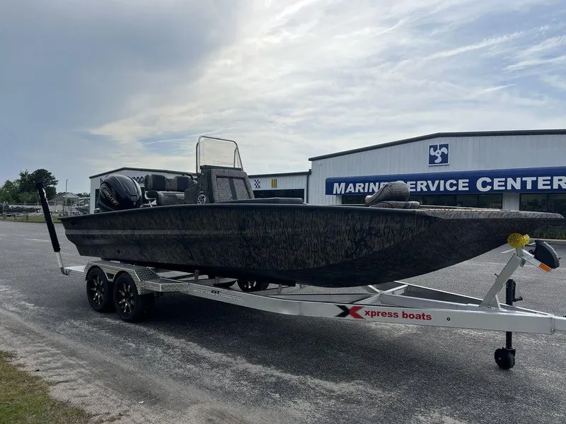 Slide: The Image of 2025 Xpress X23B Lounge boat on trailer at marine service center. - 4