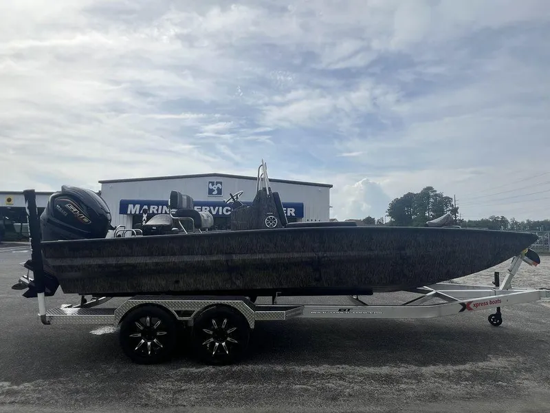 Slide: The Image of 2025 Xpress X23B Lounge boat on trailer, parked at marine service center. - 5