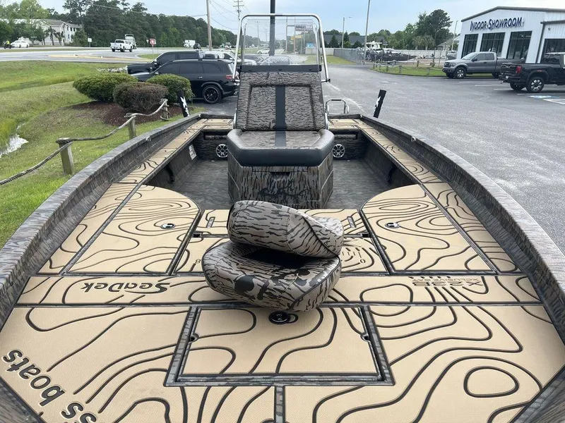 Slide: The Image of 2025 Xpress X23B Lounge boat with patterned deck, parked near a showroom. - 9