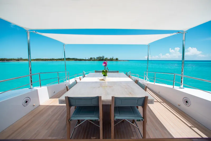 Slide: The Image of Outdoor dining area on 2017 Mengi Yay 105 Custom Explorer yacht, overlooking turquoise sea. - 25