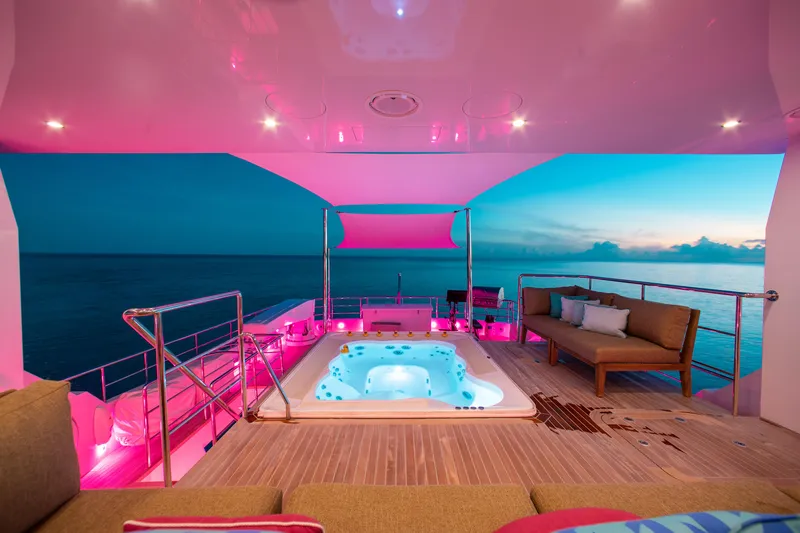 Slide: The Image of Luxurious yacht deck with jacuzzi, ambient pink lighting, and ocean view at sunset. - 31