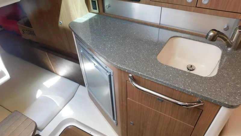 Slide: The Image of 2017 Boston Whaler 315 Conquest interior with kitchenette, featuring sink and countertop. - 12