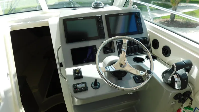 Slide: The Image of 2017 Boston Whaler 315 Conquest helm with dual screens and steering wheel. - 13